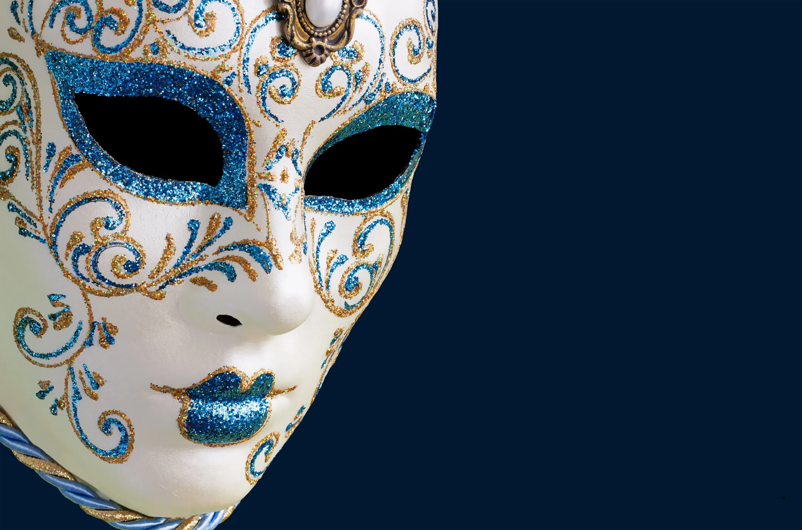 Un masque vénitien blanc et bleu, symbole du « Bal des ombres »